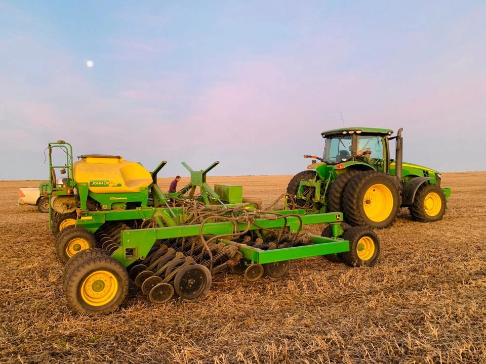 Tractor con sembradora de discos en el lote, al amanecer