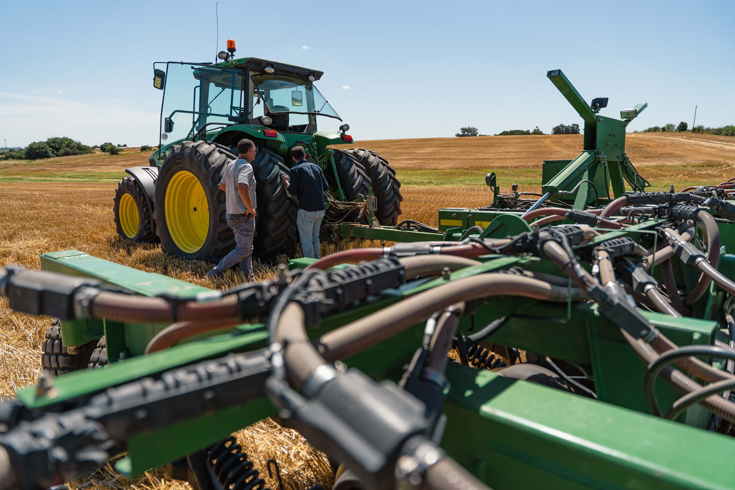 Dos operarios junto al tractor y la sembradora neumática