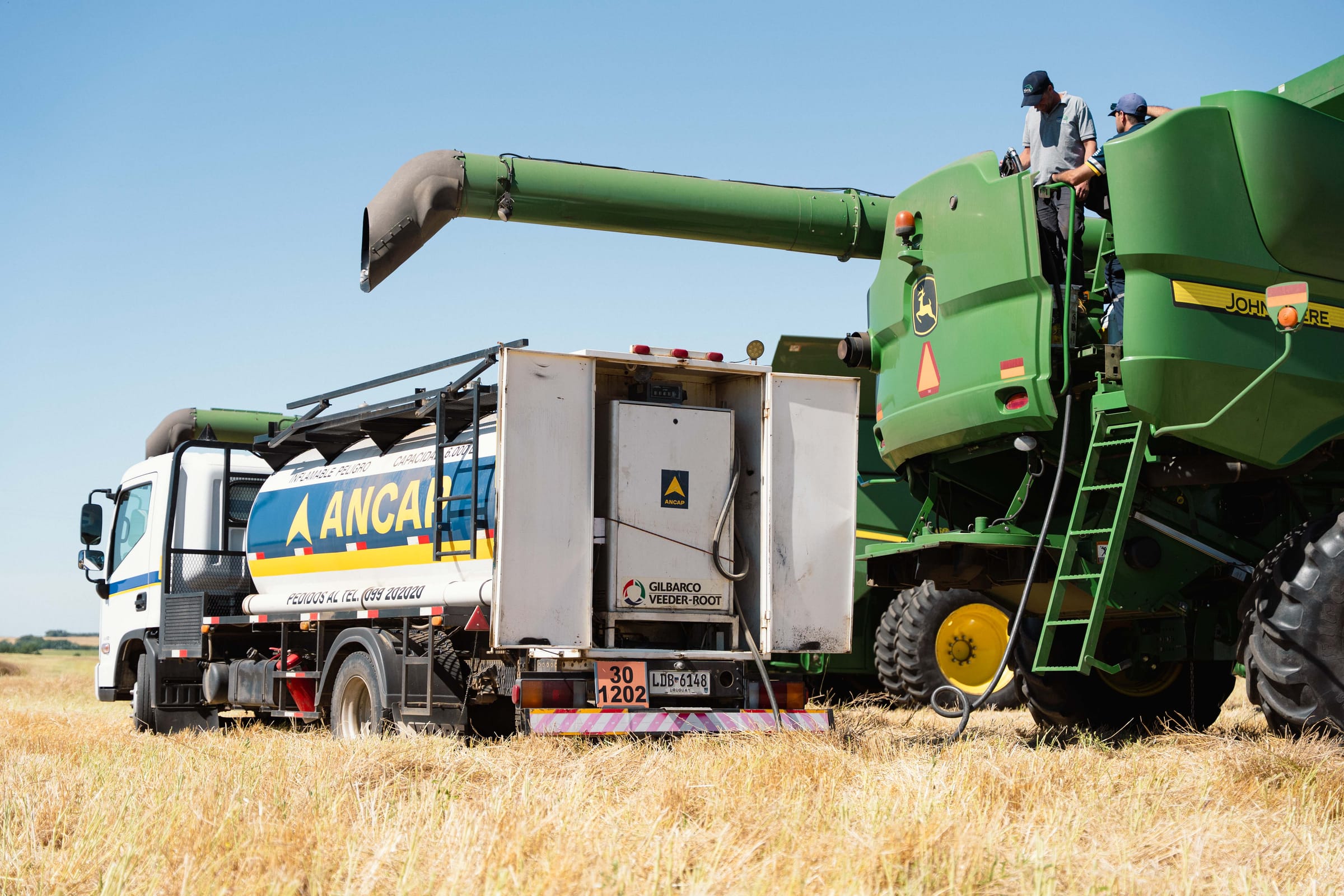 Camión cisterna cargando combustible a la cosechadora en el lote