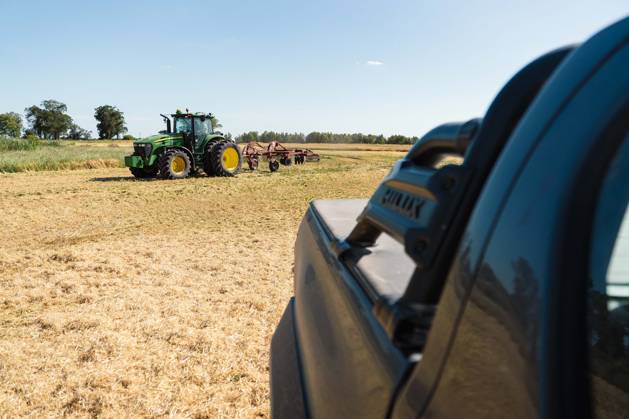 Tractor con rastra en el lote, visto desde la camioneta