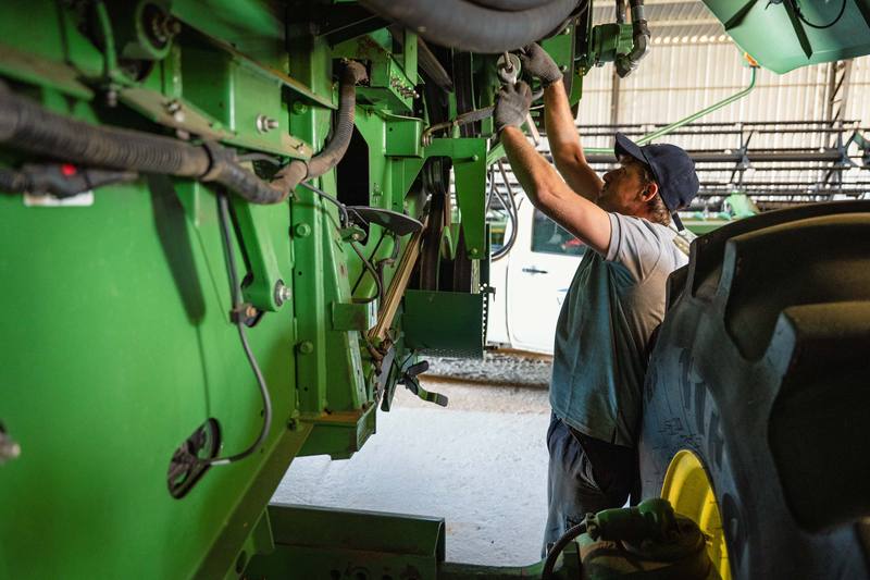Mecánico trabajando bajo la cosechadora
