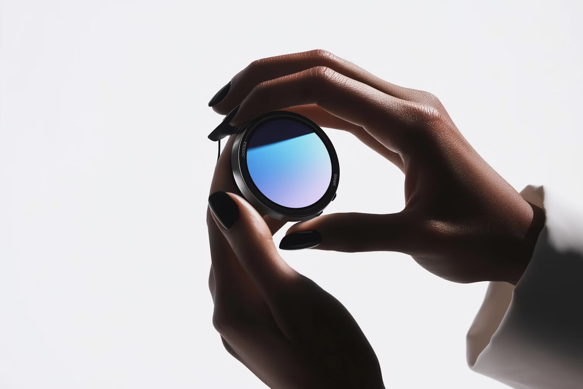 Hand holding a round lens with a blue gradient