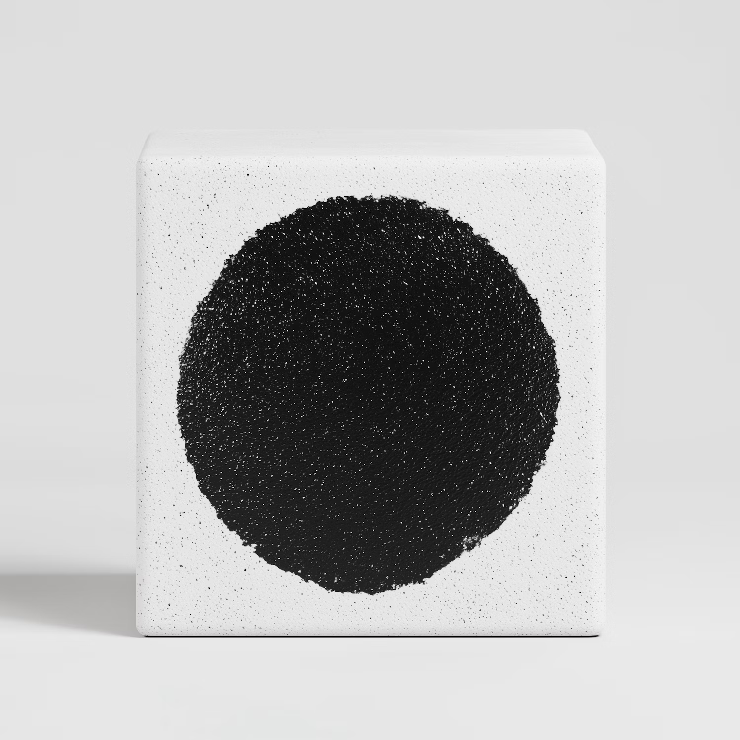 Black textured circle on a white block