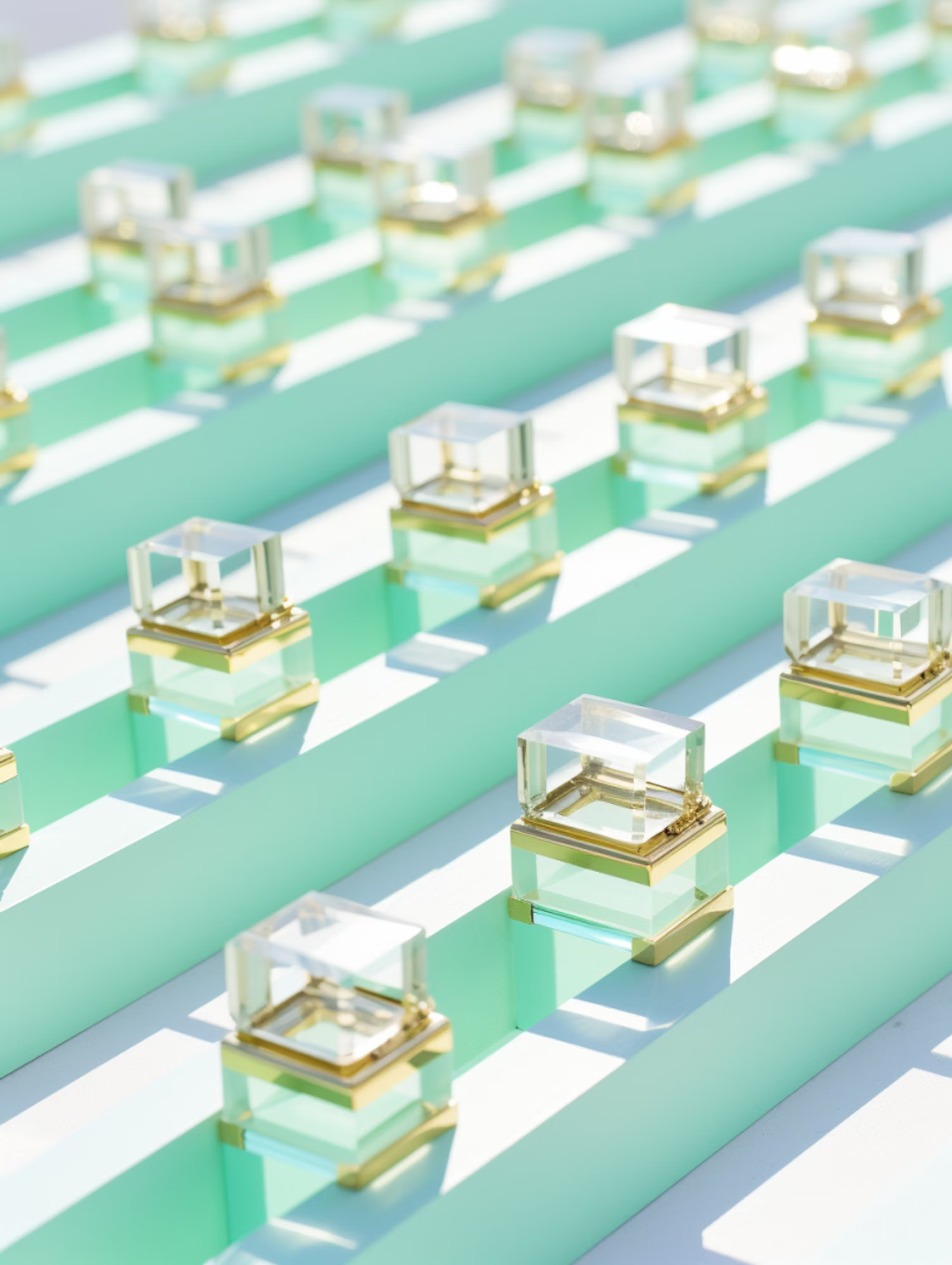 Rows of glass perfume bottles on mint stripes