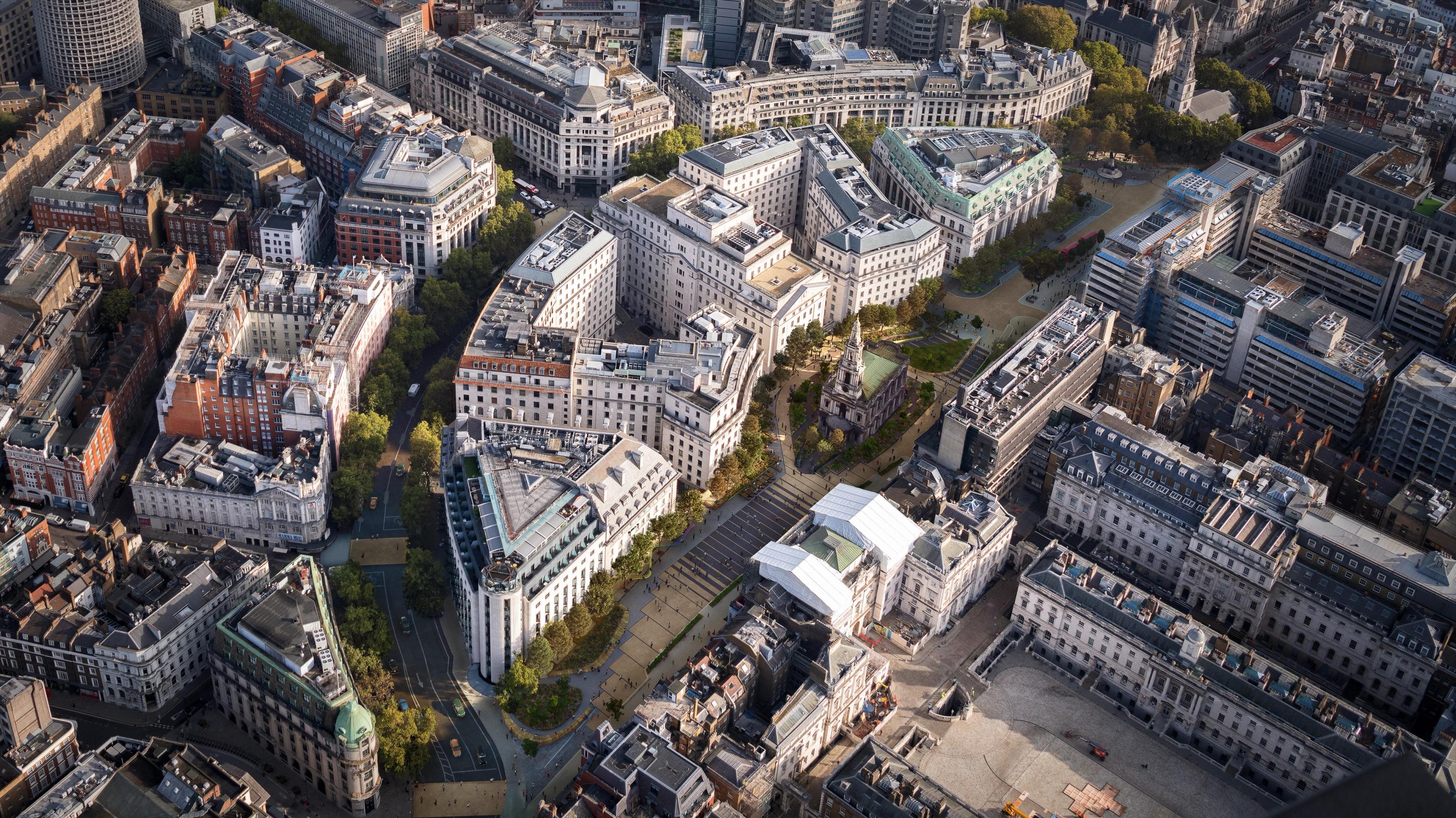 Aerial view of a dense city with a mix of historic and modern architecture, streets, and a visible church spire.