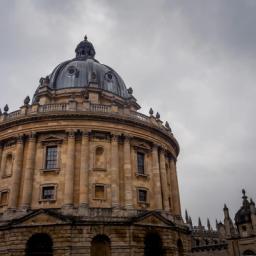 The Radcliffe Camera, a grand circular stone building with a large dome, under a cloudy sky.