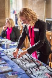 A woman from the event planning team arranges name tags at a table.