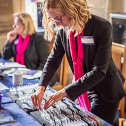 A woman from the event planning team arranges name tags at a table.