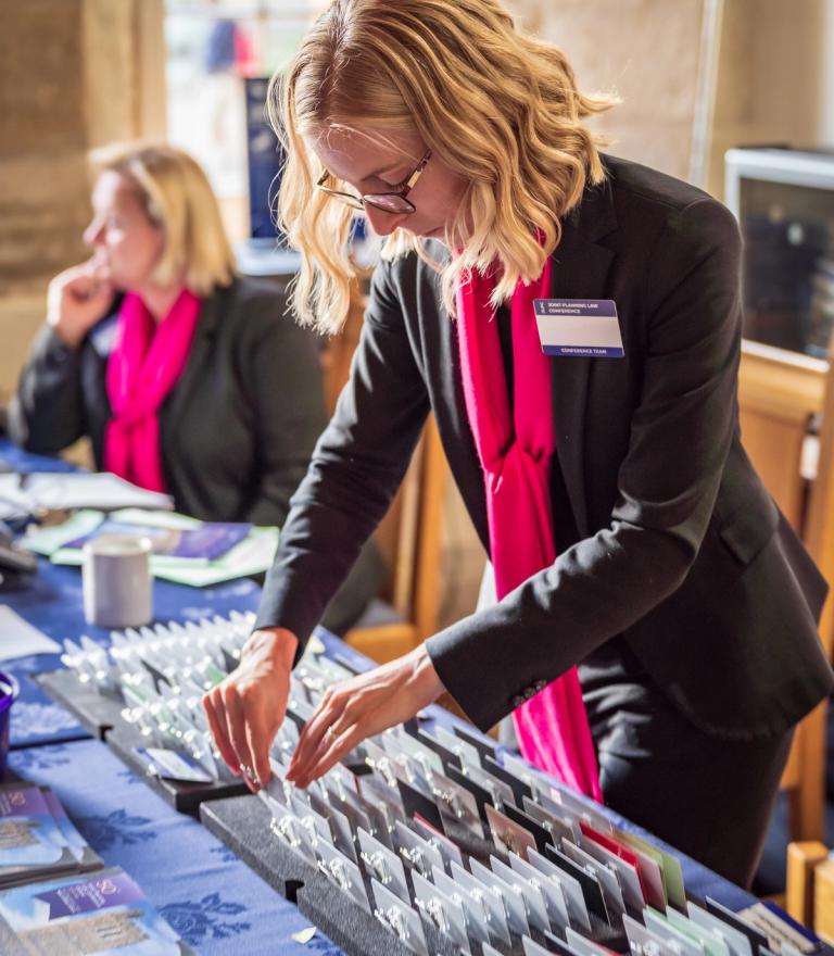 A woman from the event planning team arranges name tags at a table.