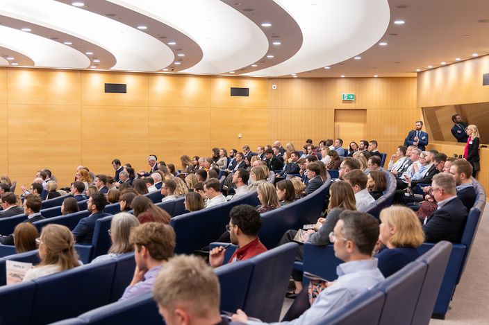 a large group of people are sitting in an auditorium .