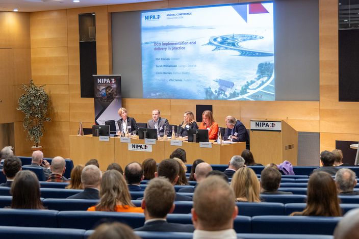 a large group of people are sitting in an auditorium watching a presentation