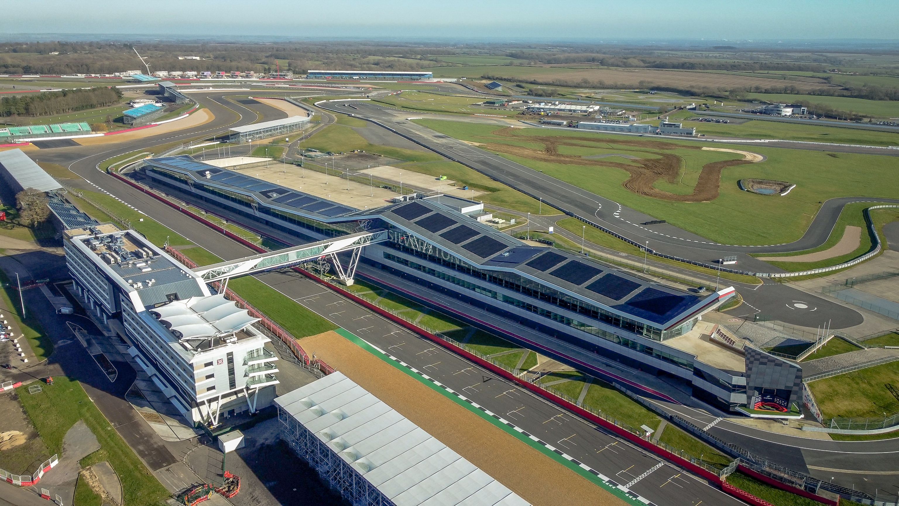 Aerial view of a modern racing circuit, showing buildings and multiple track layouts.