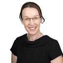 Headshot of a smiling woman with glasses and a pearl necklace.