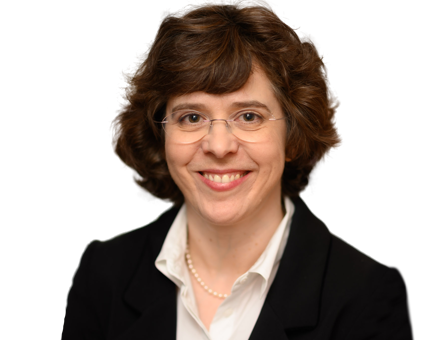 A smiling woman with short brown hair and glasses, wearing a black blazer and pearl necklace.