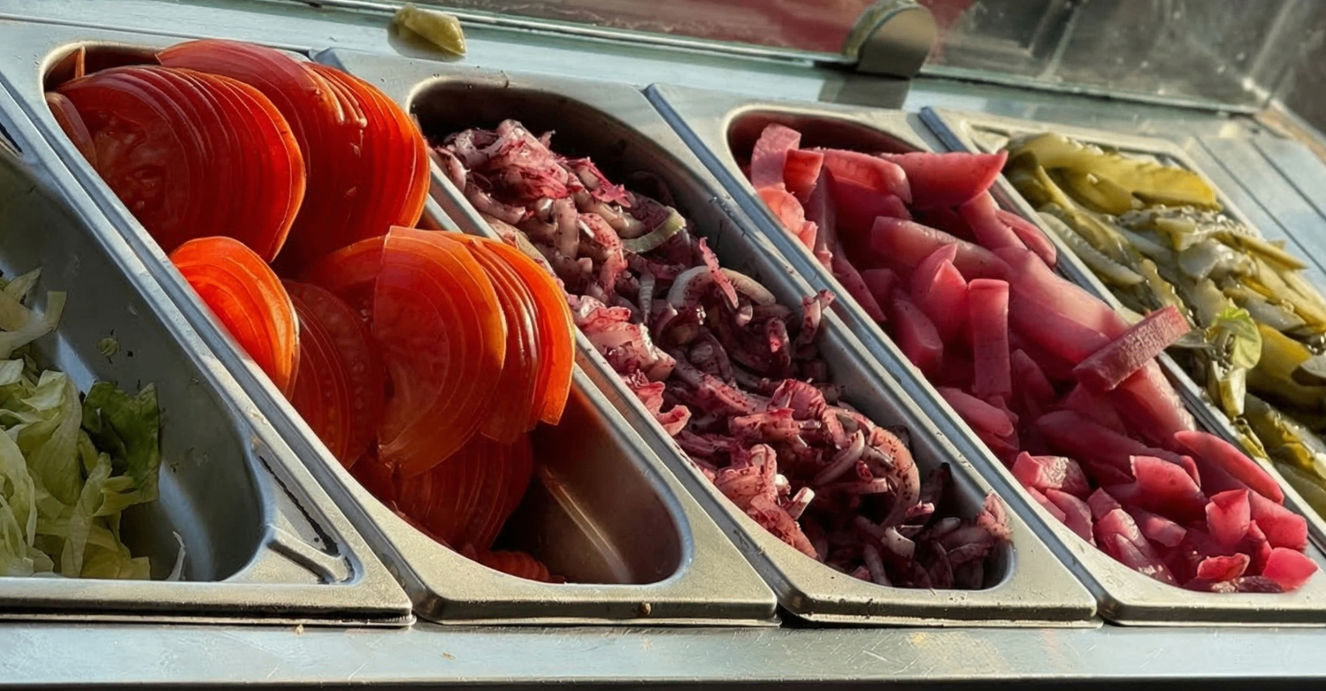 Świeże dodatki do kebaba – pomidory, cebula, sałata i marynowane warzywa