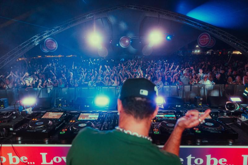 POV behind the DJ booth with packed crowd