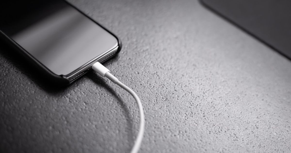 CarPlay Battery Widget: How to See Your iPhone Battery While Driving — black smartphone with charger cord connected