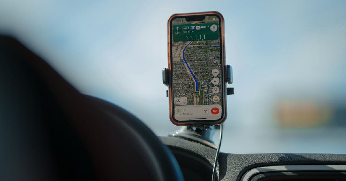 Smartphone displaying navigation app with route on car dashboard