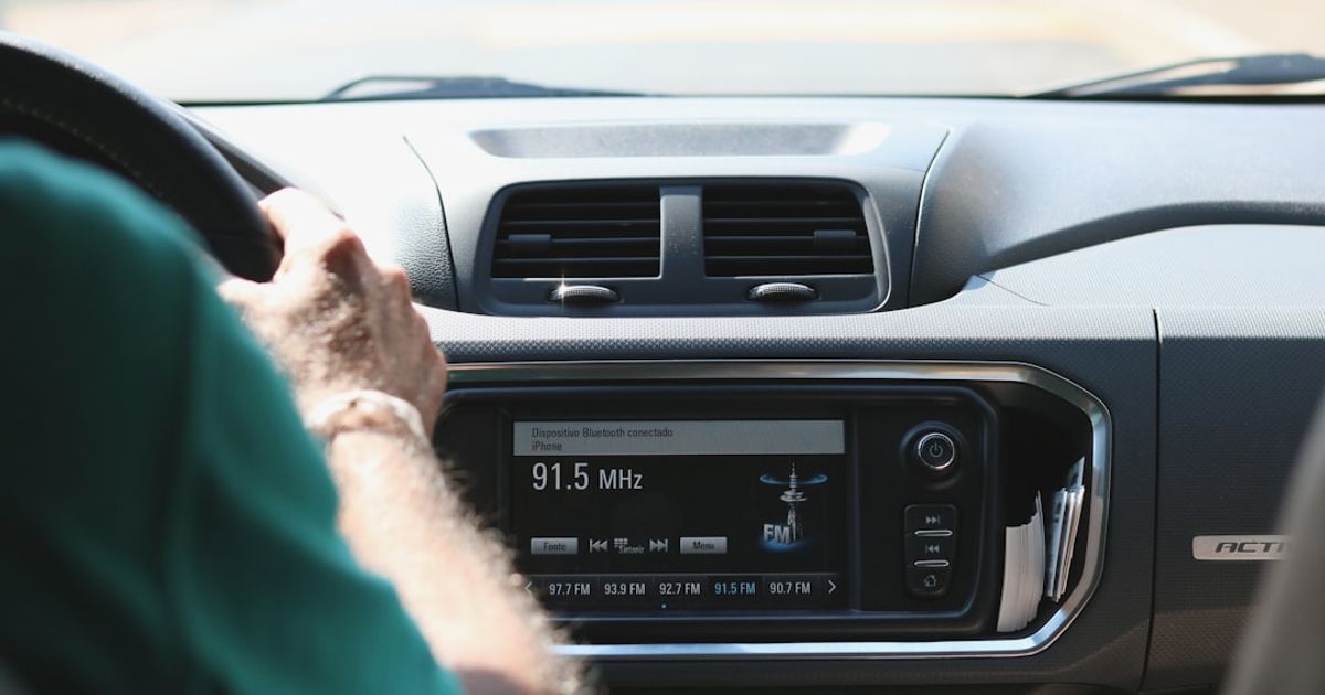 How to Put Lyrics on Apple CarPlay (Apple Music, Spotify, YouTube Music & More — 2026) — black car stereo turned on at 2 00