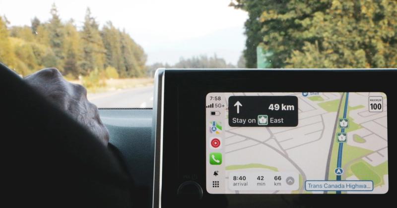 Apple CarPlay navigation on a car screen with the open road ahead