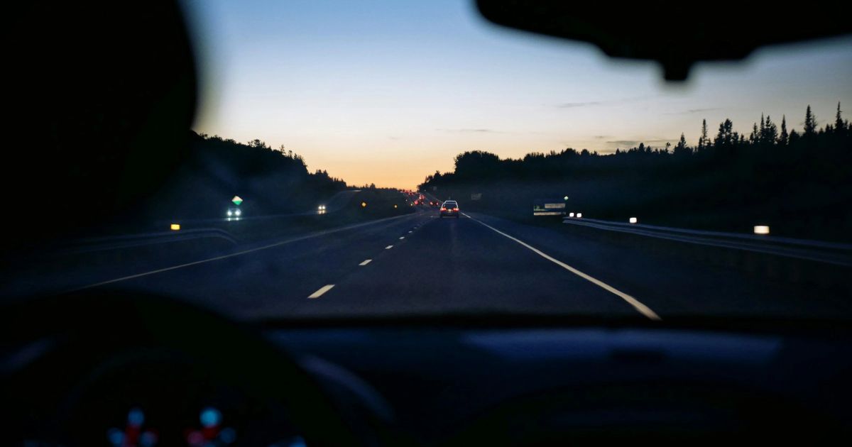 Highway at dusk through the windshield