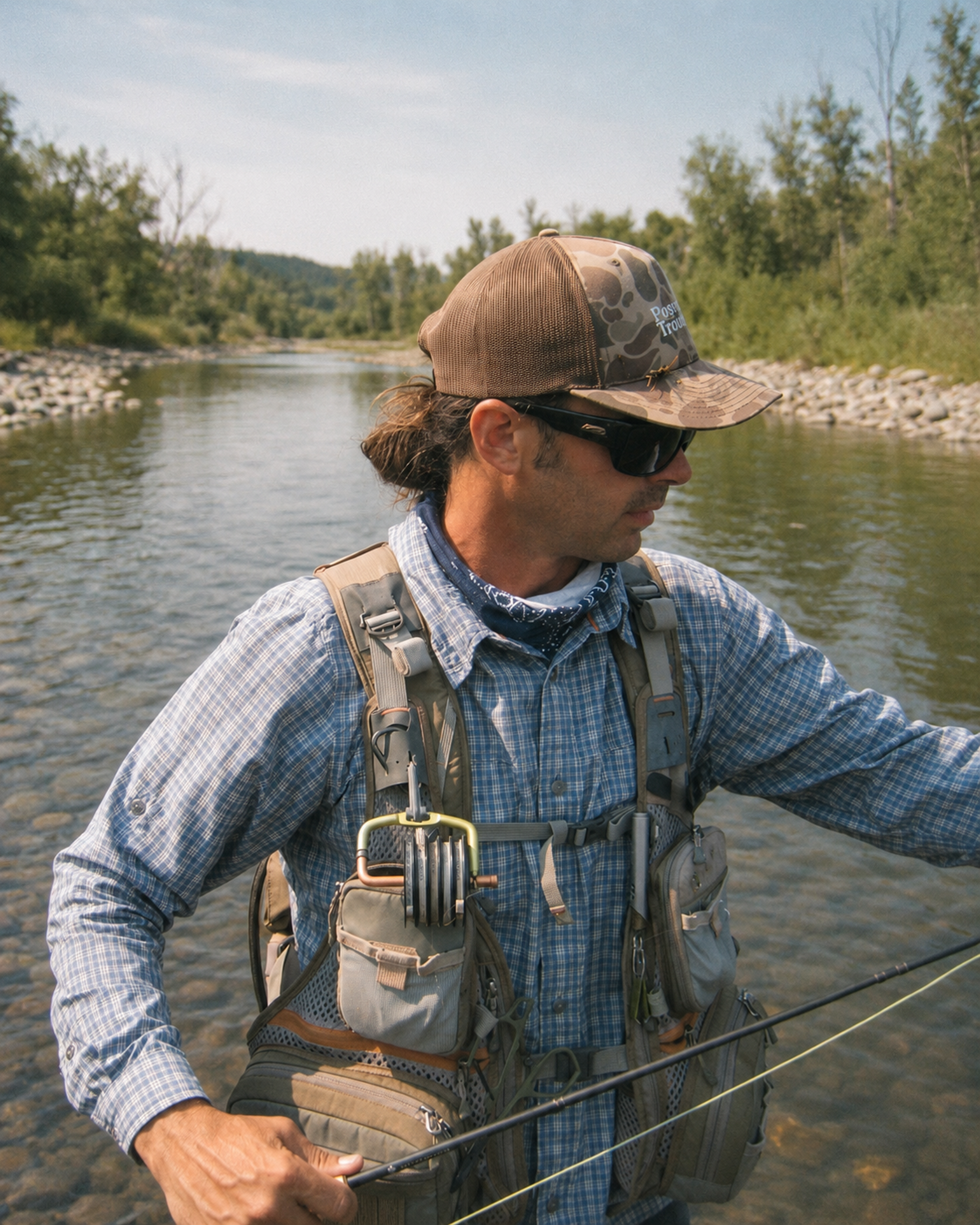 Max Stratton holding a fly rod while standing in a Colorado river