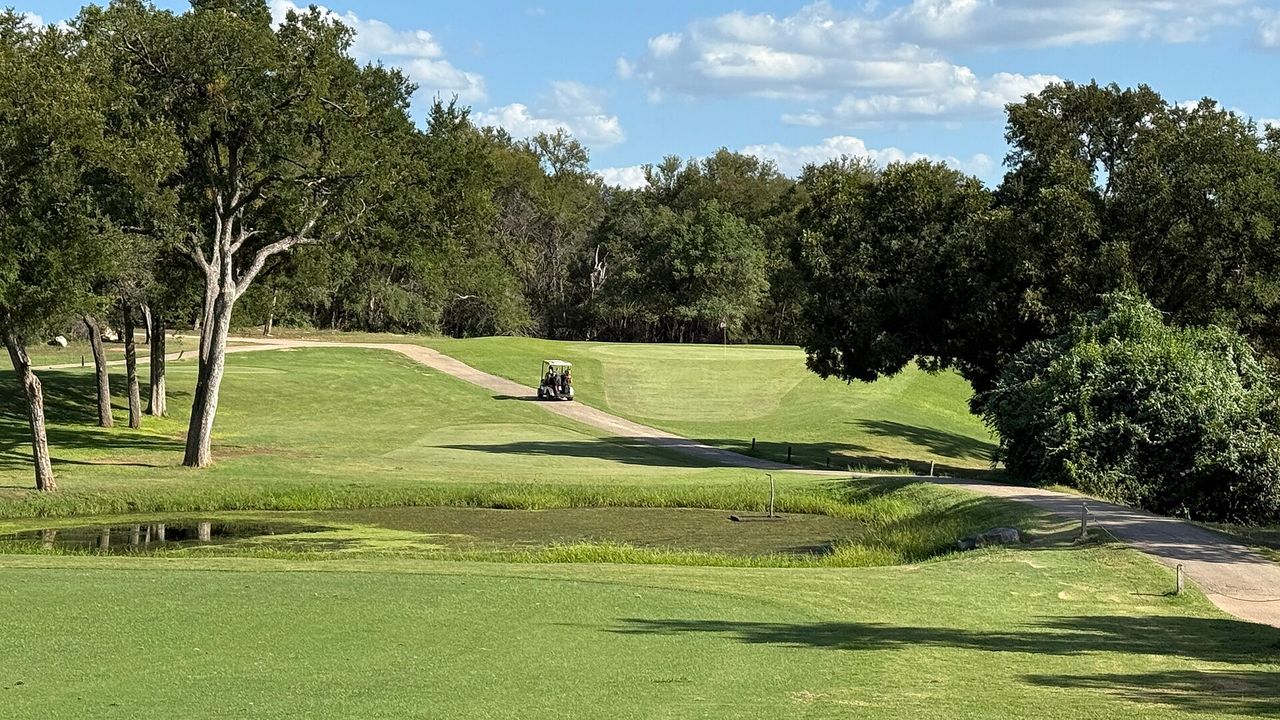 A green fairway and pond on a Texas golf course.