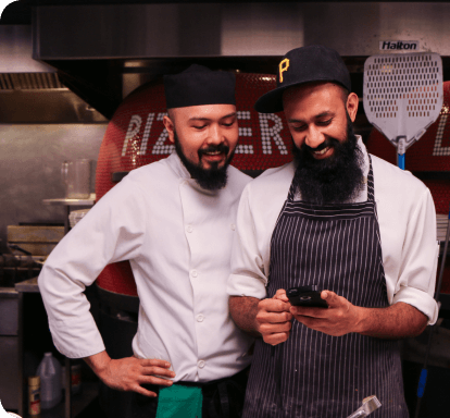 Happy chefs using restaurant technology apps
