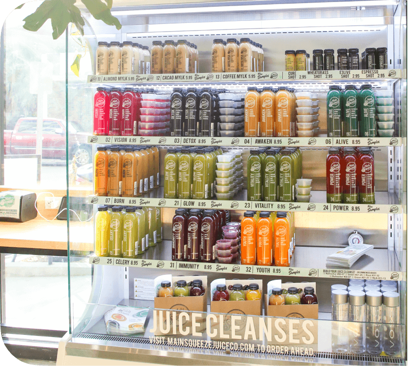 Fridge a Juice Co. full of bright fresh juices in glass containers.