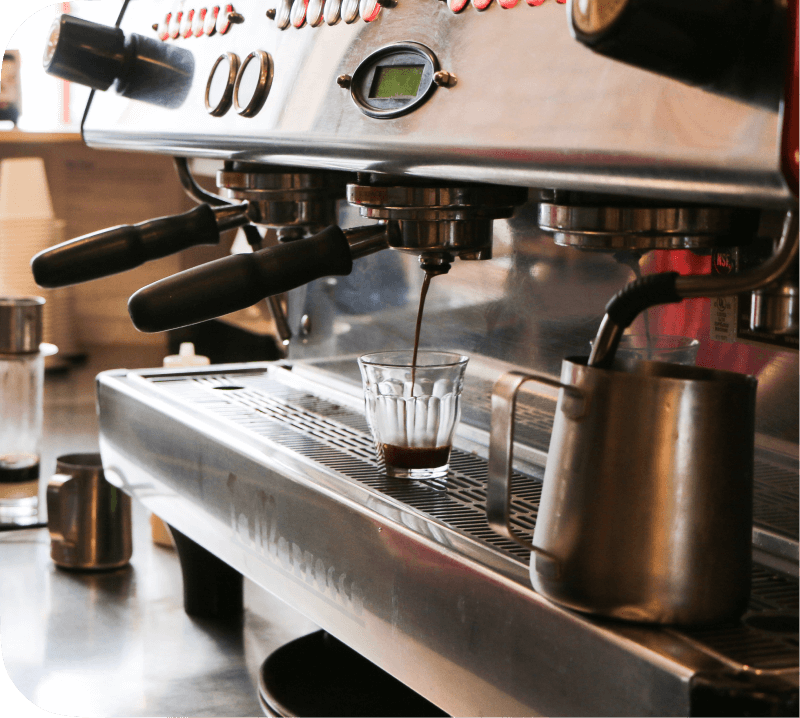 Espresso machine extracting coffee into an espresso cup.