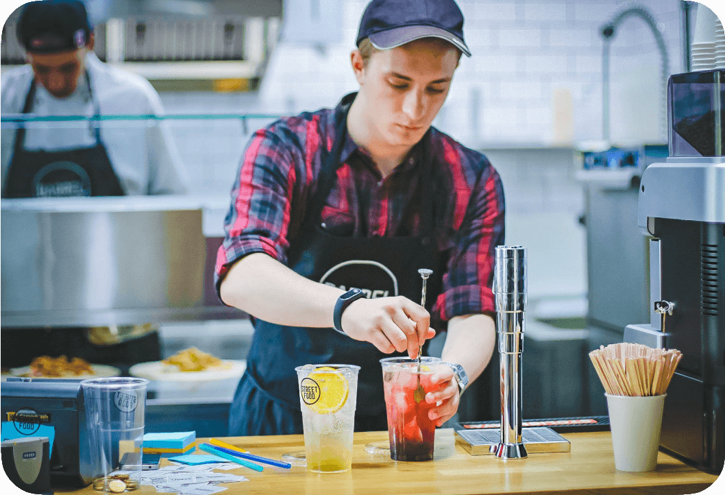 Bartender mixing a red fruit based cocktail.