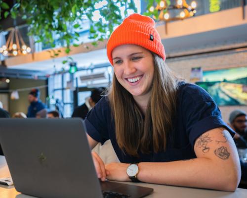 Happy restaurant manager using workforce management on the computer.