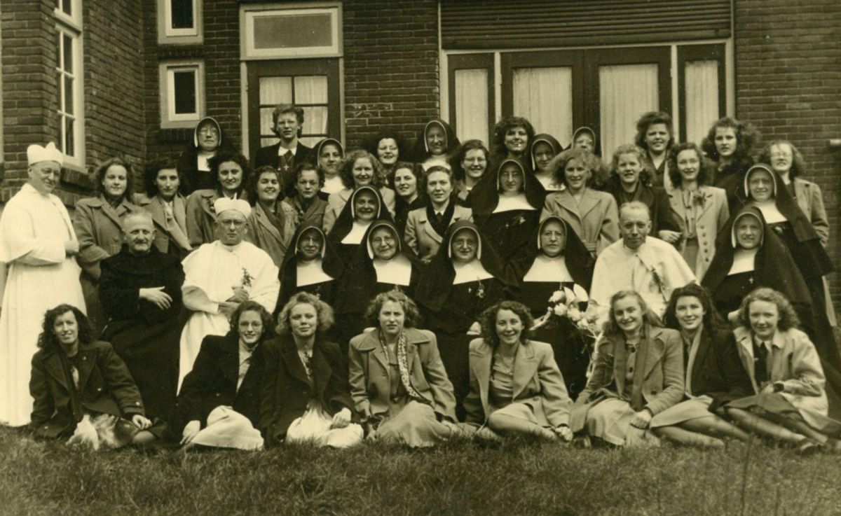 Zusters en leerlingen van internaat O.L. Vrouw van Lourdes, en vier paters van de Orde van Norbertijnen, waaronder pastoor Hiëronymus Breugelmans (foto: BHIC, collectie Abdij van Berne 1695-008611