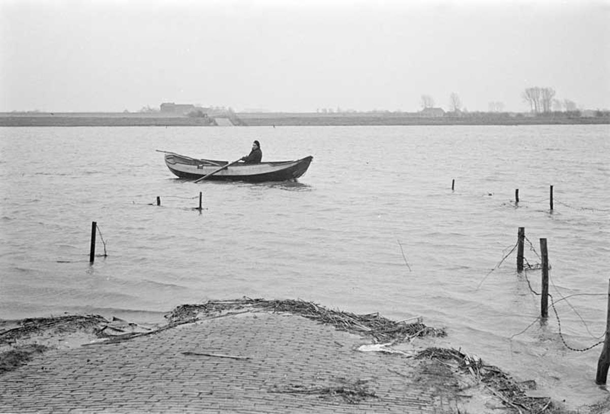 Veerman Van Swam onderhoudt met een geleende roeiboot o.a. het traject Overlangel-Keent voor voetgangers en fietsers, januari 1952 (foto: Daan Scholte. Bron: Stadsarchief Oss nr. DSN0976_33120)