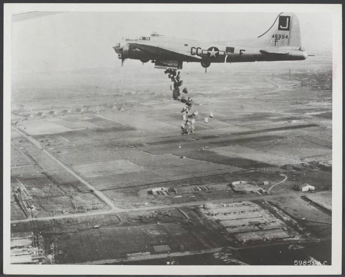Foto: een Amerikaanse bommenwerper dropt voedsel boven vliegveld Valkenburg bij Leiden (Foto: US Air Force. Bron: Nationaal Archief, coll. Spaarnestad nr. 7.000SPAond_30069_049. Publiek domein)
