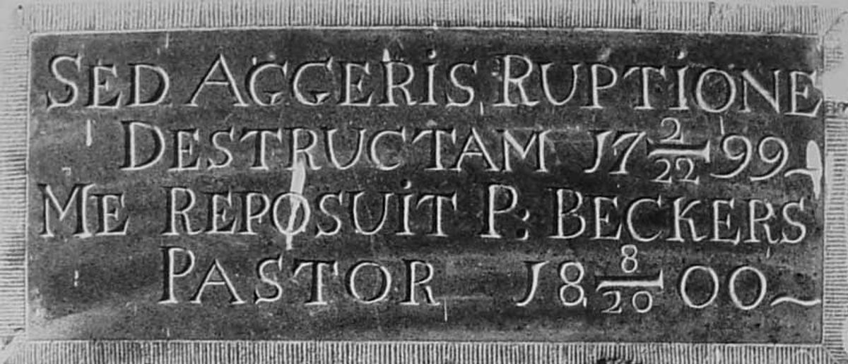Gedenksteen in de hal van de huidige kerk te Haarsteeg met (vertaald) de tekst “Verwoest door de dijkbreuk op 22 februari 1799 heeft Pastoor Beckers mij op 20 augustus 1800 opnieuw gelegd” (bron: Streekarchief Langstraat Heusden Altena nr. VLM05841)