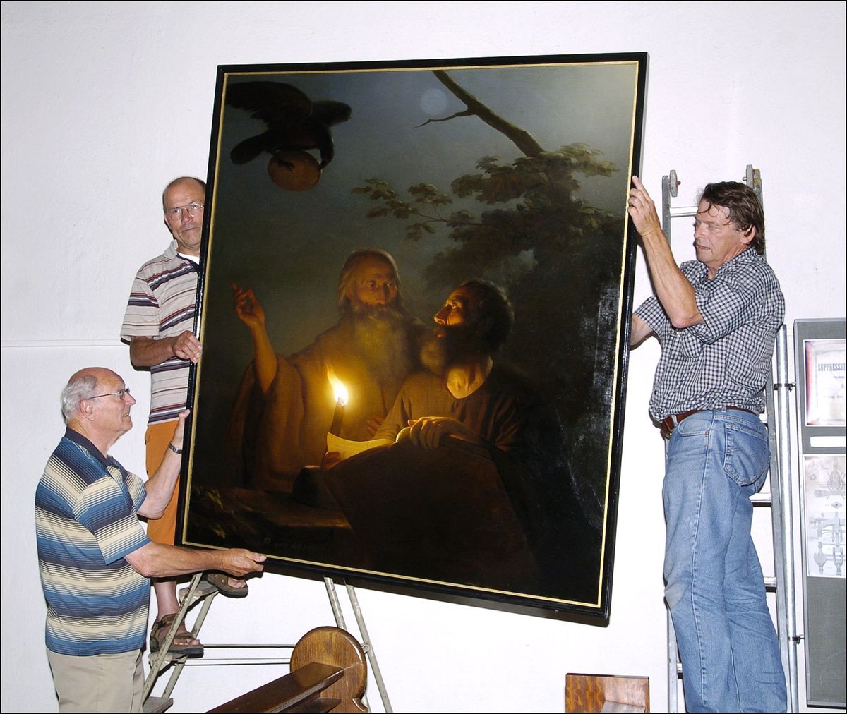 Schilderij geschonken door Petrus van Schendel aan de H. Antonius Abt kerk in Terheijden, voorstellende ‘Nachtbezoek van de H. Paulus aan de H. Antonius’. In 2006 werd het schilderij gerestaureerd en weer op zijn plaats gehangen in de kerk door restaurateur John Post (rechts) met kerkvrijwilligers Frans van Gils (links) en Leo Vermeulen (foto: Johan van Gurp; Stadsarchief Breda JVG20060719008)