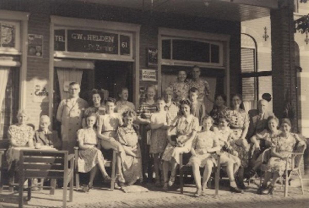 Foto gemaakt in de jaren ‘40 van de vorige eeuw. Familie Van Helden en hotelgasten. Moeke Van Helden in gestreepte jurk, vader die in 1944 is overleden is staat er ook op. Dochter Riet is geboren in 1931, staat op de foto als meisje van zo’n 10-12 jaar met vlechtjes en met de armen over elkaar.