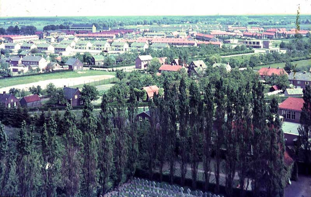 Op voorgrond het kerkhof van de parochie, afgebakend met de hoge Italiaanse Populier. In het midden van links naar rechts de Odiliastraat, verder buurtschap Hoeve (deze en de vorige foto sluiten hierbij aaneen)