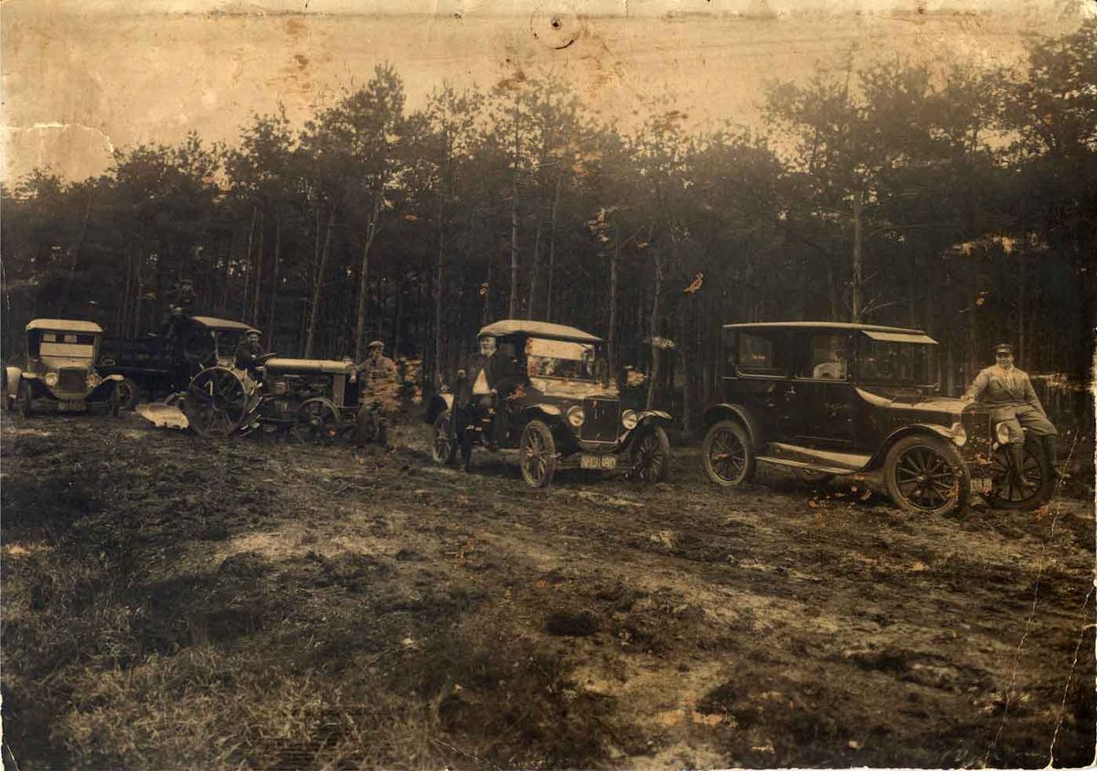 Rally in de buurt van Bergen op Zoom, midden jaren '20. Vermoedelijk is de genomen op één van de landgoederen van Marinus Geluk. Zelf staat hij waarschijnlijk geleund tegen de tweede auto van rechts (N-13880; zie ook detail). De auto daarnaast is van de N.V. Cultuuronderneming Zoomland (N-13879). Uiterst links is op een auto het kenteken N-12024, op naam van J.G. van Breemen te lezen. (Bron: coll. F. van Breemen)