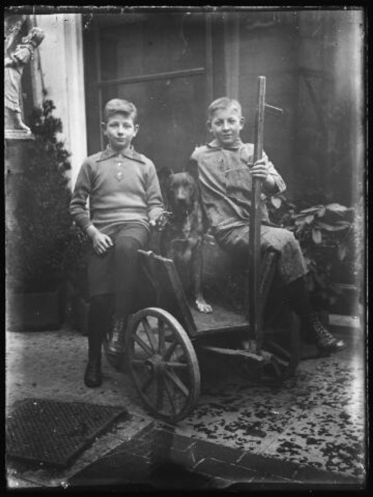 Besoijen Twee jongens en hond op hondenkar, ca. 1920