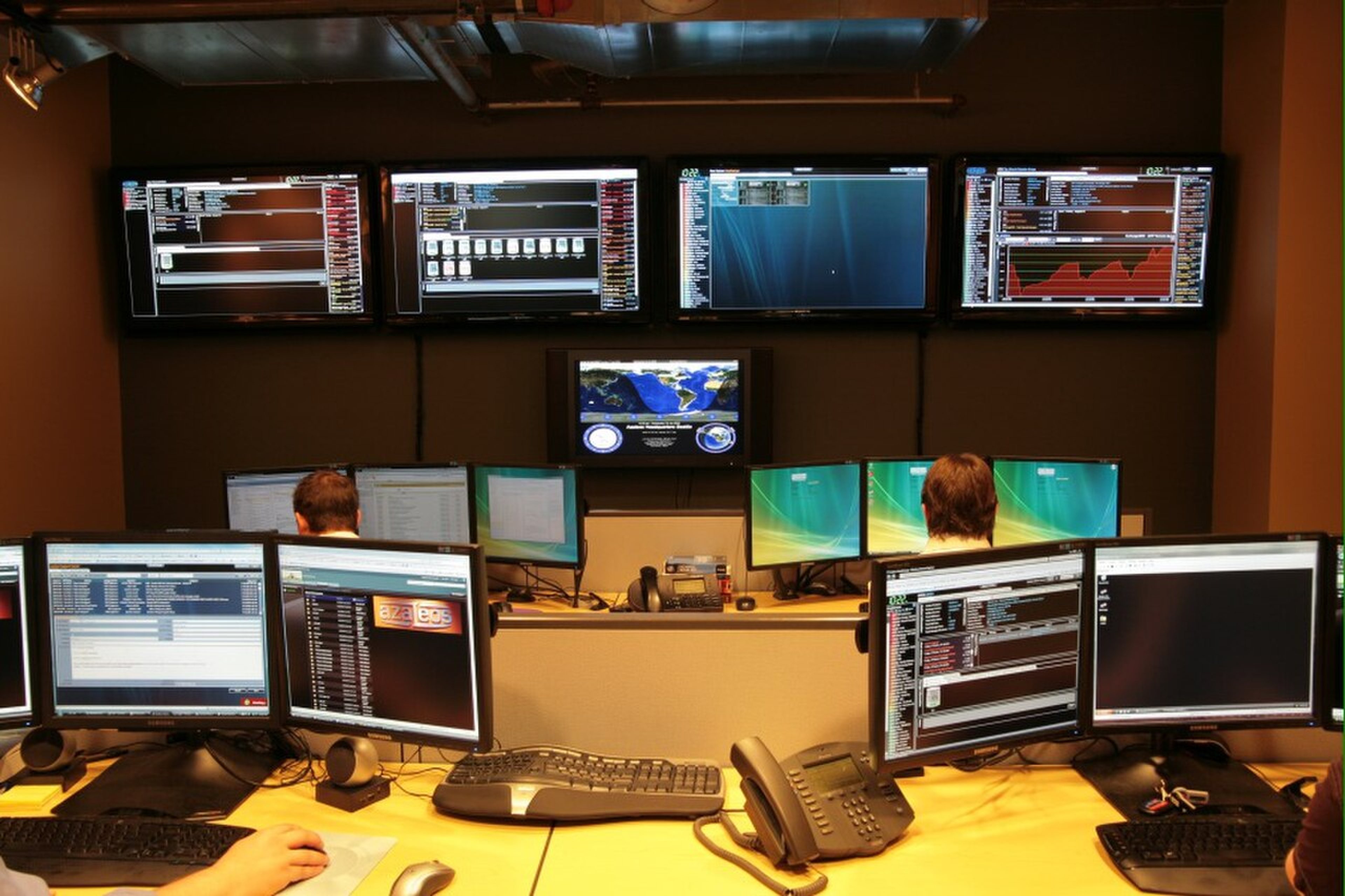Managed services team monitoring servers and network dashboards in a business operations center