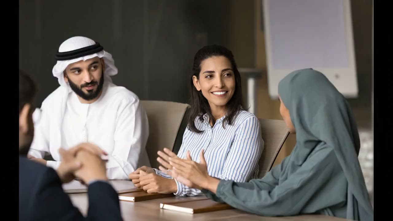 Emirati colleagues in conversation around a meeting table