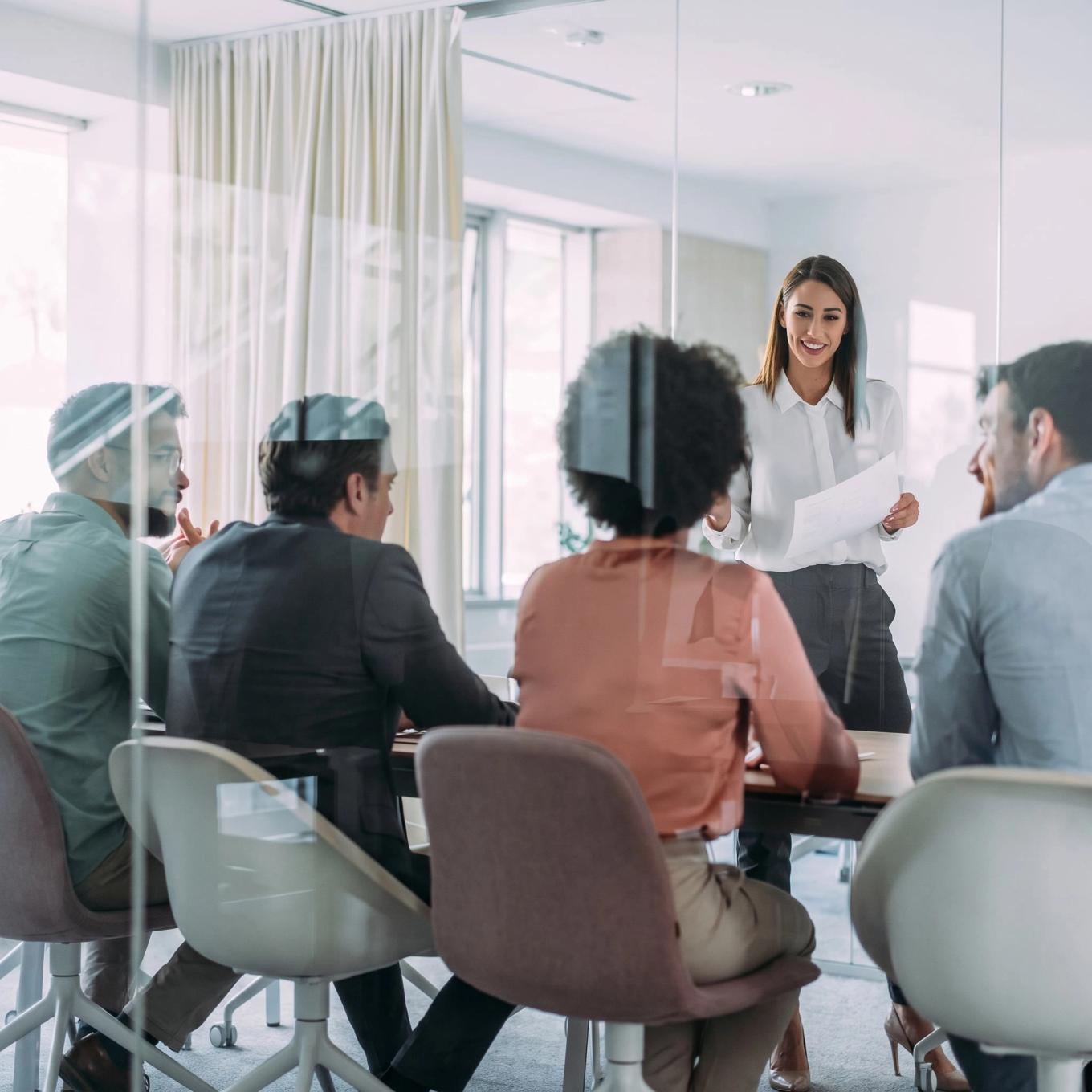 A leader presenting to colleagues around a boardroom table