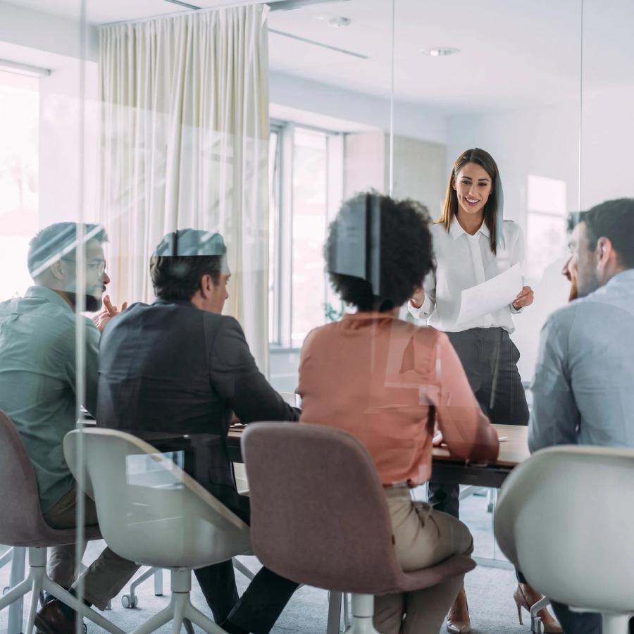 A leader presenting to colleagues around a boardroom table