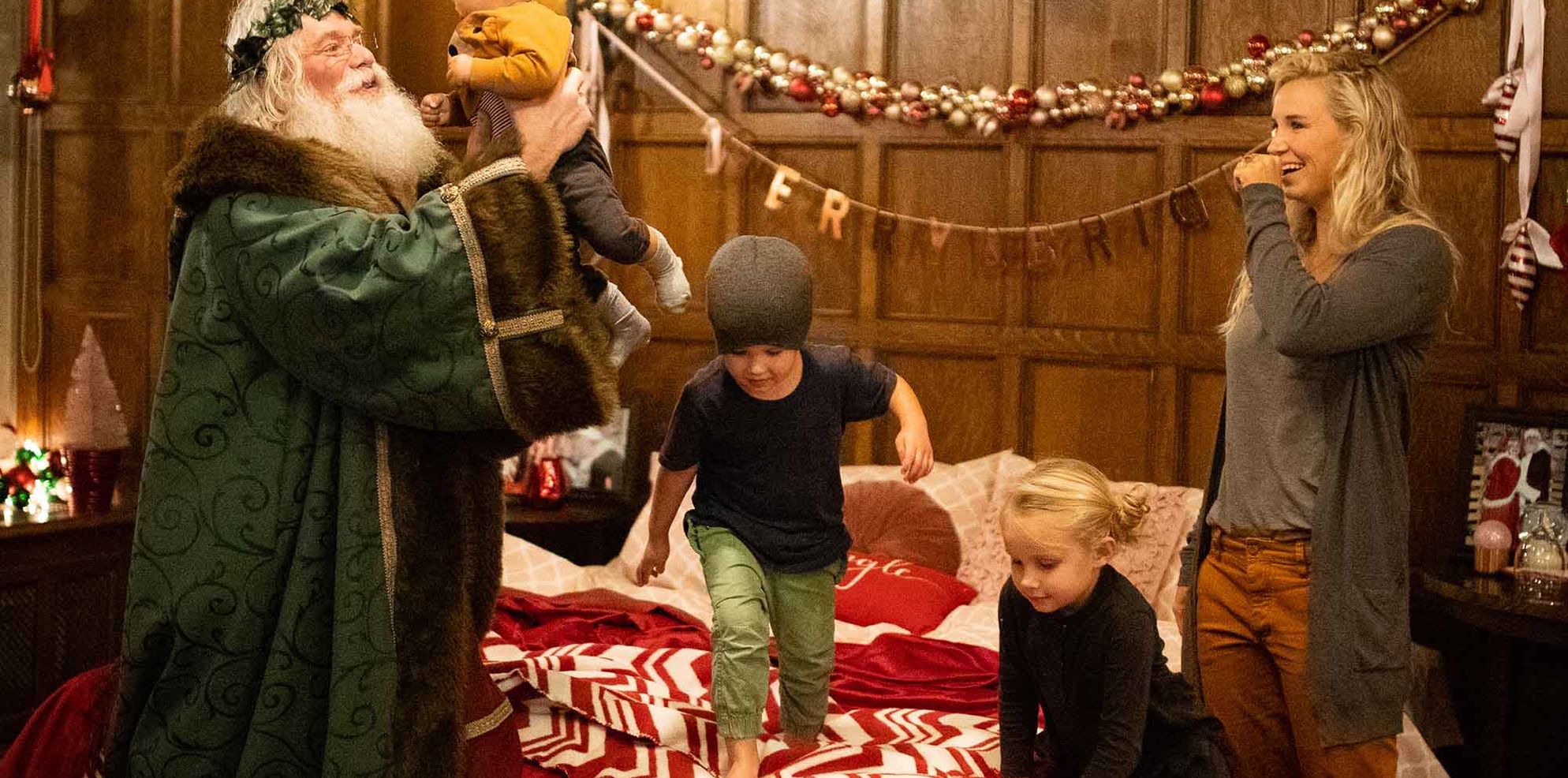 Three kids play with Santa Claus in the Santa suite at the Banff Springs Hotel in Banff National Park.