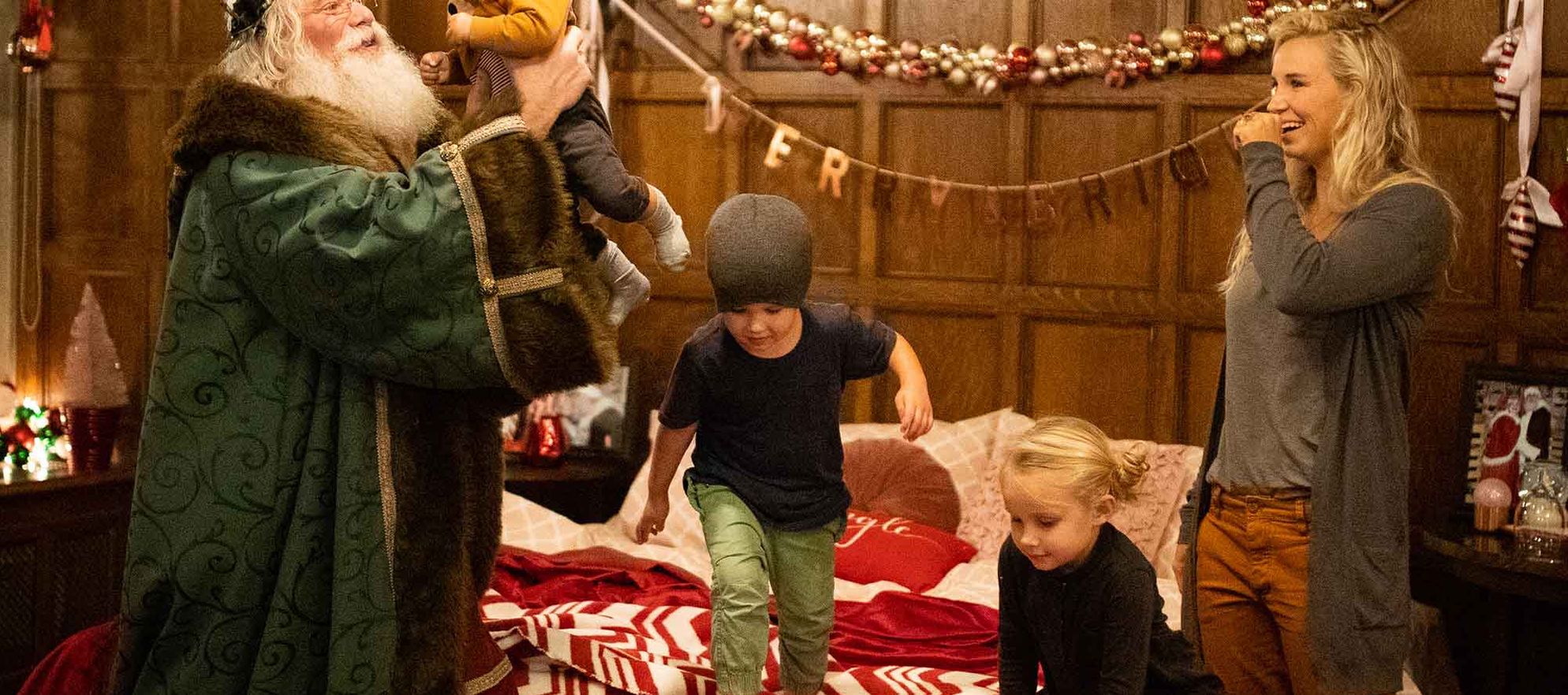 Three kids play with Santa Claus in the Santa suite at the Banff Springs Hotel in Banff National Park.