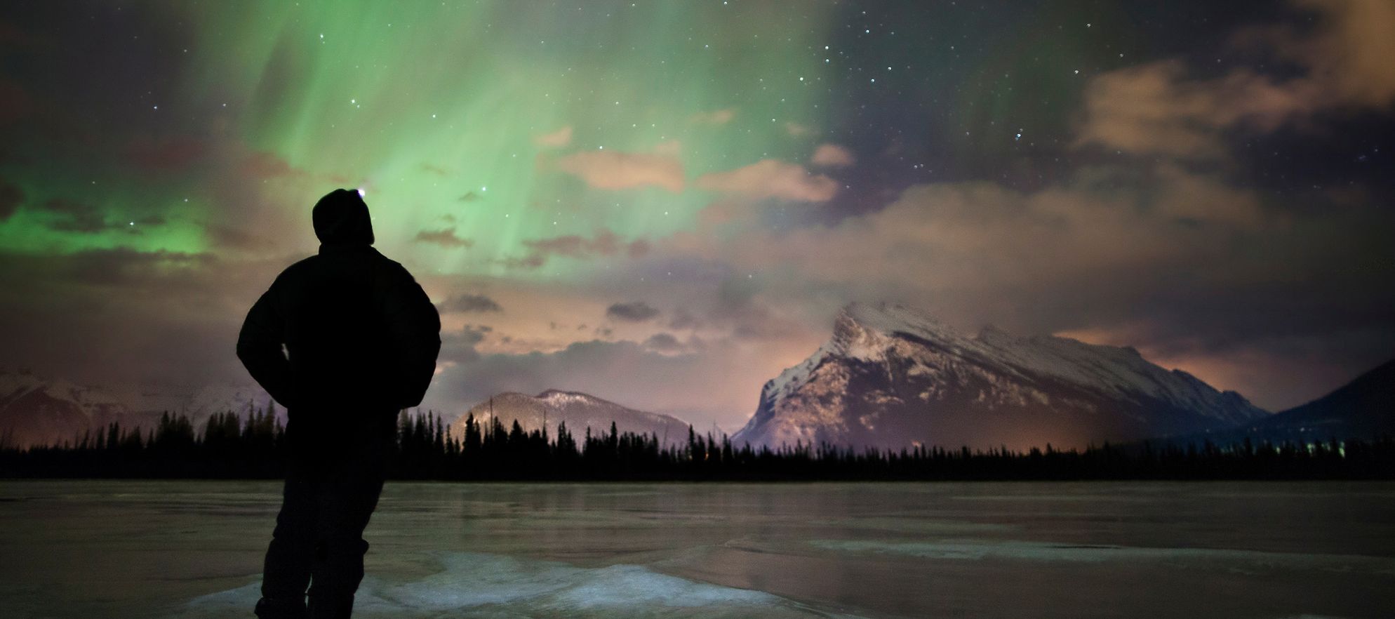 A man watches the Northern Lights above the skies of Banff and Lake Louise