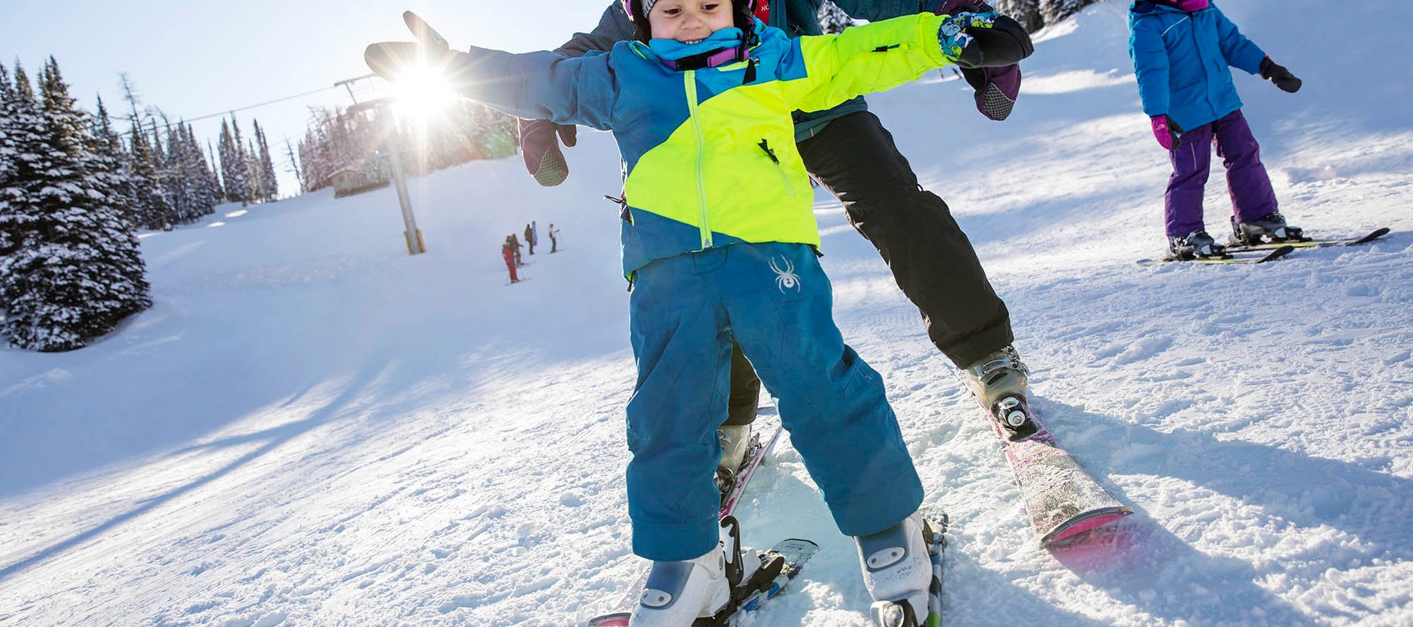 A little kid and their mom go downhill skiing at Banff Sunshine Village in Banff National Park.