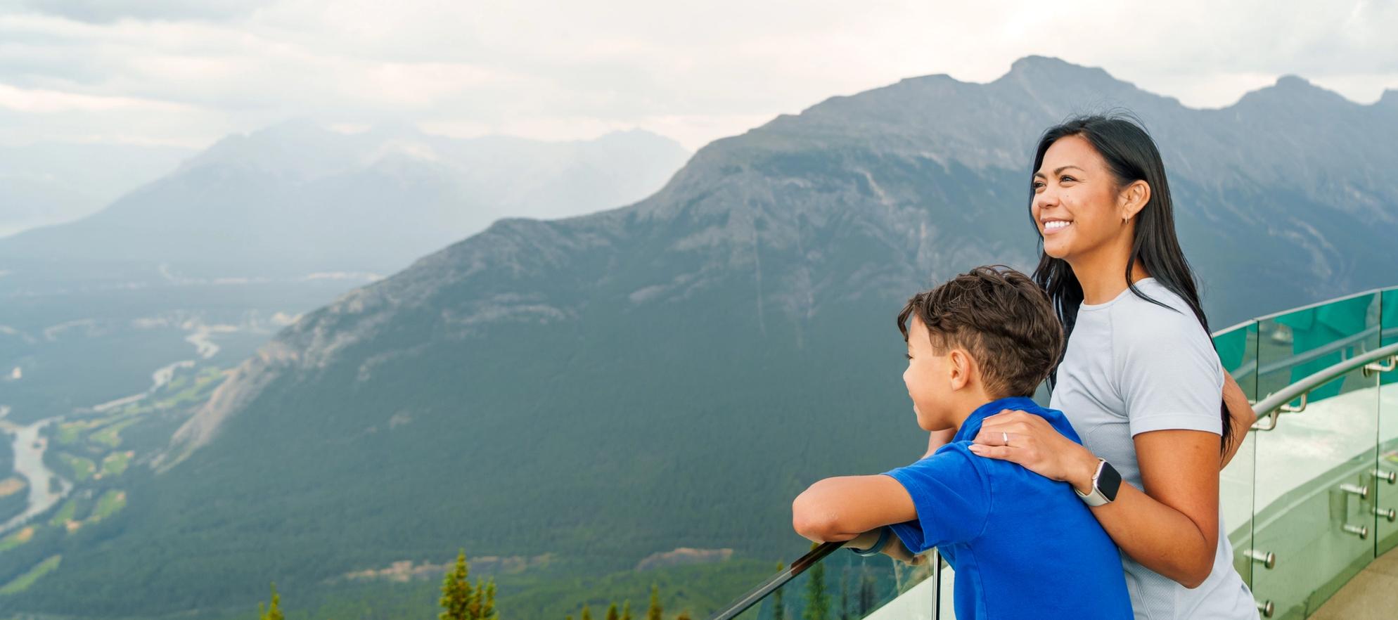 A mother and child taking in the views from the top of the Banff Gondola in the summer.